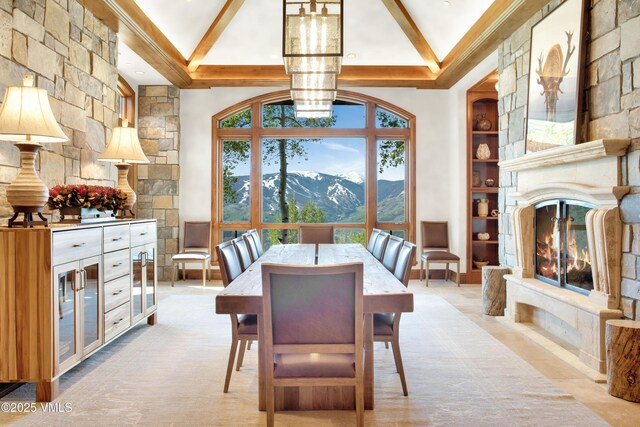 46 Jasmine, Avon, CO 81620 - dining area featuring beam ceiling, a mountain view, a chandelier, high vaulted ceiling, and a large fireplace