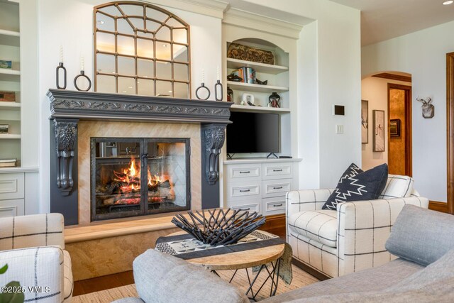 46 Jasmine, Avon, CO 81620 - living room with built in shelves, a high end fireplace, arched walkways, and wood finished floors