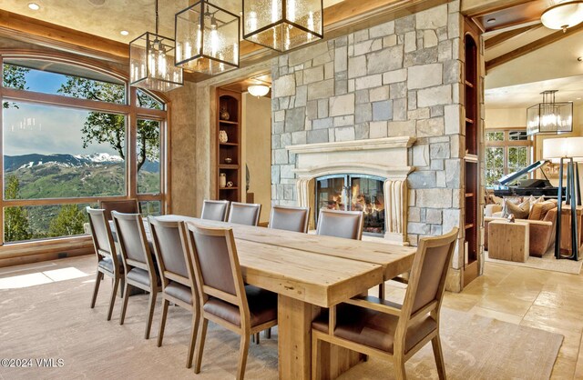 dining space featuring beamed ceiling, a mountain view, plenty of natural light, and a fireplace