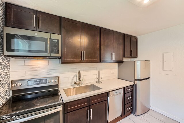 871 W Beaver Creek Blvd Unit A9, Avon, CO 81620 - kitchen featuring appliances with stainless steel finishes, a sink, decorative backsplash, dark brown cabinets, and light countertops
