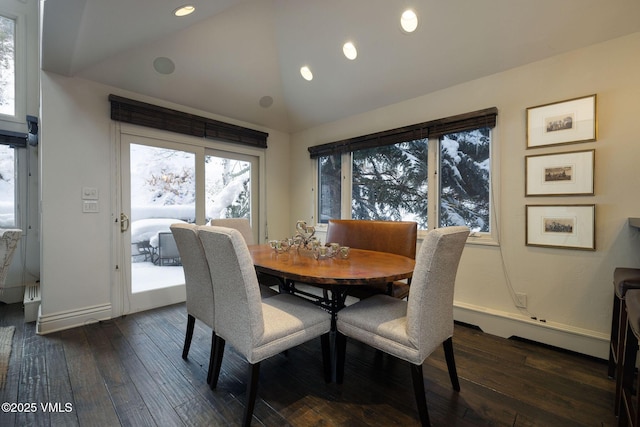 dining area featuring vaulted ceiling and dark hardwood / wood-style flooring