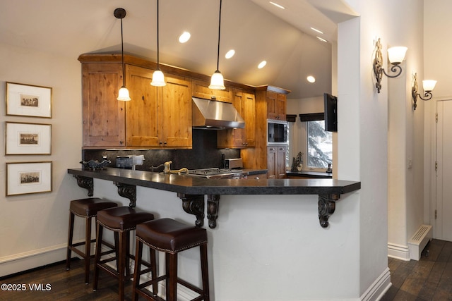 kitchen featuring hanging light fixtures, black microwave, a kitchen breakfast bar, and kitchen peninsula