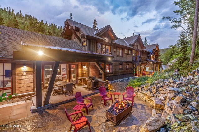 back of house with a fire pit and a patio area