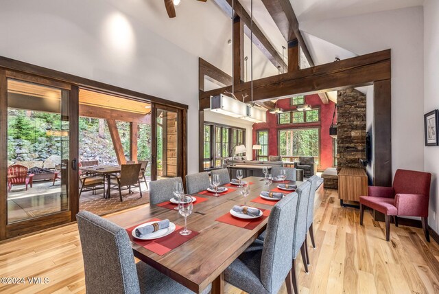 dining room featuring beamed ceiling, high vaulted ceiling, and light hardwood / wood-style flooring