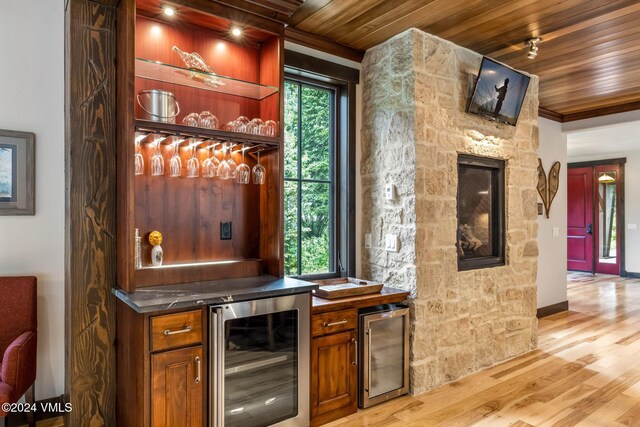 bar with wine cooler, ornamental molding, wood ceiling, and light wood-type flooring