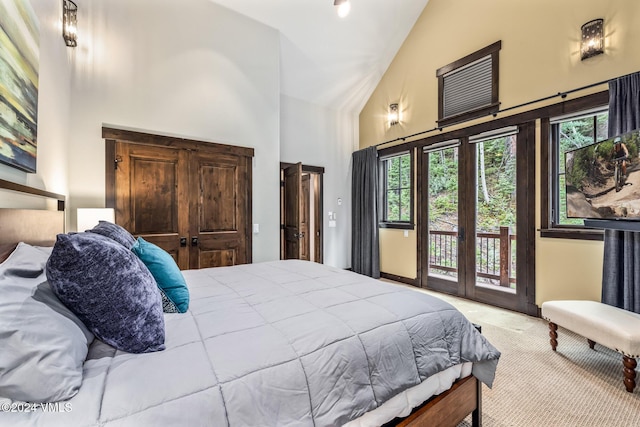 bedroom featuring access to outside, high vaulted ceiling, and french doors