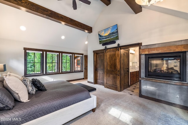 bedroom with ensuite bathroom, high vaulted ceiling, light colored carpet, a barn door, and beam ceiling