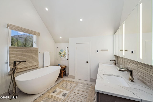 2036 Vermont Rd, Vail, CO 81657 - full bathroom with a freestanding bath, double vanity, lofted ceiling, decorative backsplash, and tile patterned flooring