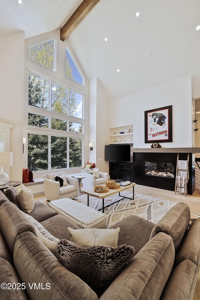 2036 Vermont Rd, Vail, CO 81657 - living area featuring high vaulted ceiling, beamed ceiling, recessed lighting, wood finished floors, and a glass covered fireplace