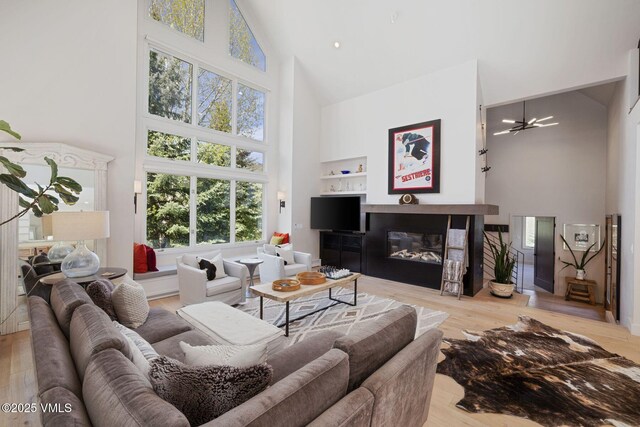 2036 Vermont Rd, Vail, CO 81657 - living area with high vaulted ceiling, wood finished floors, and a glass covered fireplace