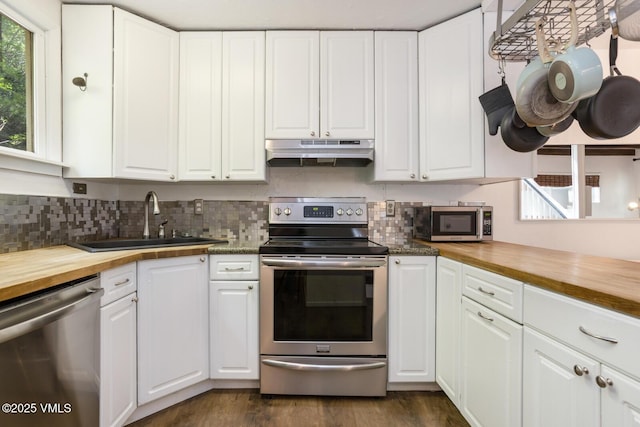 2932 Bellflower Dr Unit B, Vail, CO 81657 - kitchen with stainless steel appliances, wood counters, under cabinet range hood, a sink, and white cabinets