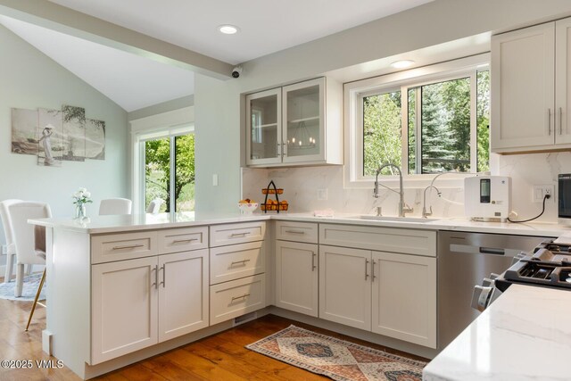 50 Hereford Rd, Edwards, CO 81632 - kitchen featuring a peninsula, light countertops, tasteful backsplash, vaulted ceiling, and glass insert cabinets