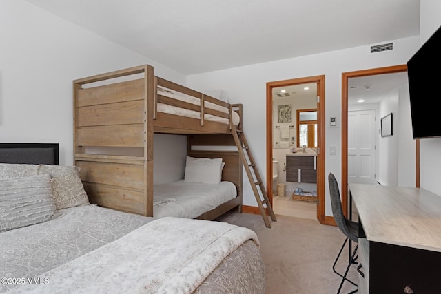 bedroom featuring ensuite bath, light colored carpet, visible vents, and baseboards