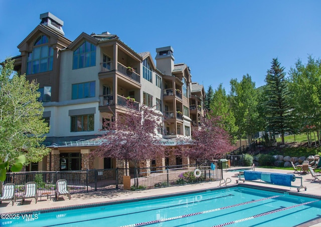 pool featuring a patio area and fence