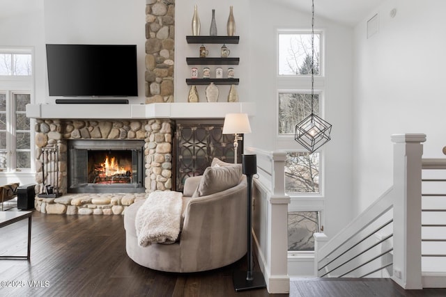 living room featuring high vaulted ceiling, wood finished floors, and a fireplace