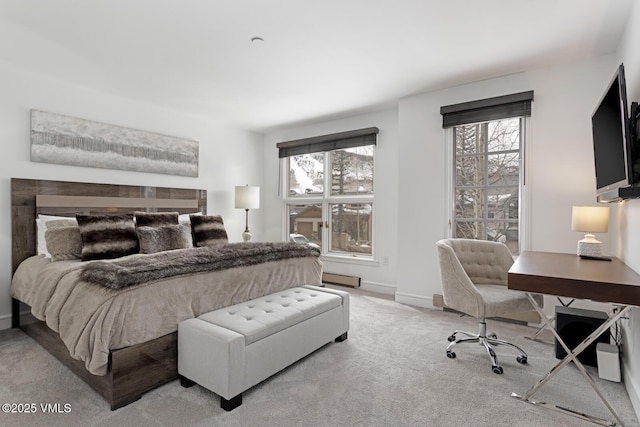 carpeted bedroom featuring multiple windows and baseboards