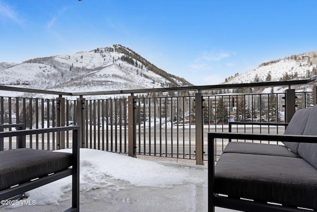 snow covered back of property with a mountain view