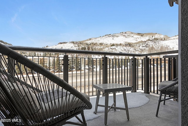 snow covered back of property featuring a mountain view