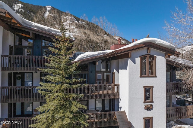 snow covered building featuring a mountain view