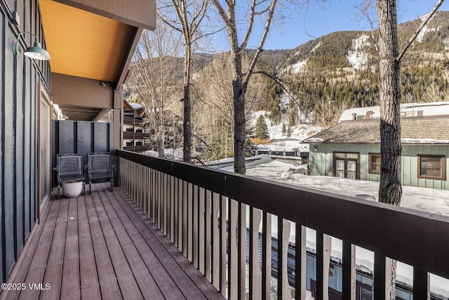 snow covered back of property featuring a mountain view