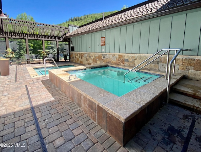 view of pool with a patio and an in ground hot tub