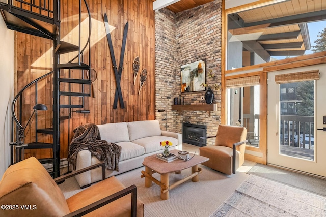 carpeted living area featuring beam ceiling, wooden walls, plenty of natural light, and wooden ceiling