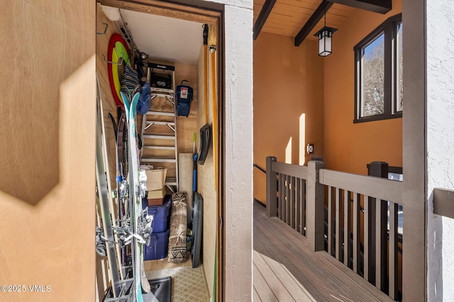 stairs featuring beamed ceiling and wood ceiling