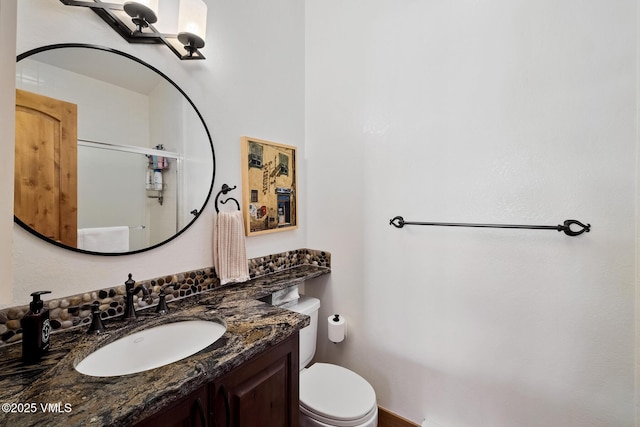 bathroom featuring an enclosed shower, toilet, and vanity