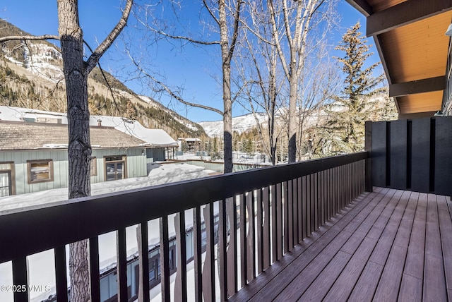 snow covered deck with a mountain view