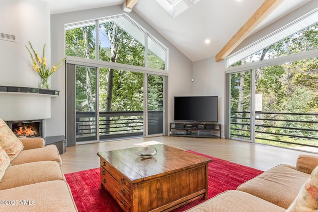 4916 Juniper Ln, Vail, CO 81657 - living room featuring beam ceiling, a glass covered fireplace, wood finished floors, high vaulted ceiling, and a skylight