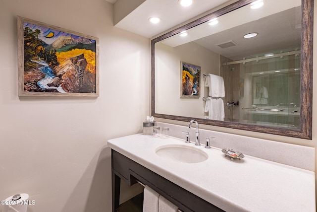 bathroom with vanity and a shower with shower door