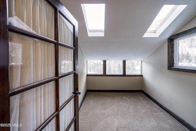 additional living space with lofted ceiling with skylight and carpet flooring