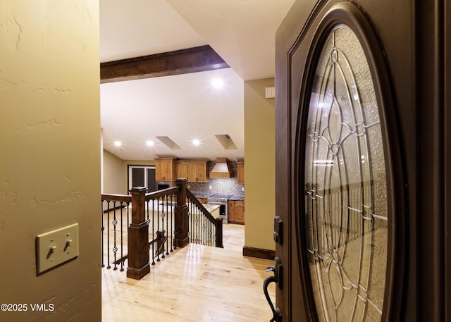 entrance foyer featuring beam ceiling and light wood-type flooring