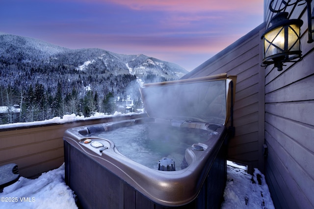 exterior space featuring a mountain view and a hot tub