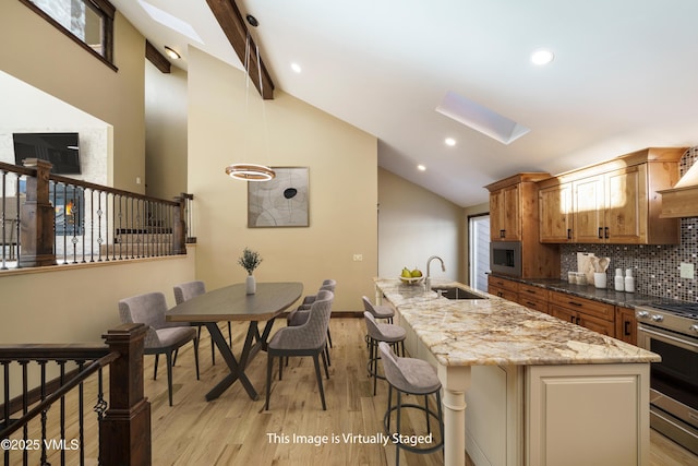 4595 Bighorn Rd Unit 5, Vail, CO 81657 - kitchen featuring stainless steel appliances, a skylight, light wood-style flooring, brown cabinets, and backsplash
