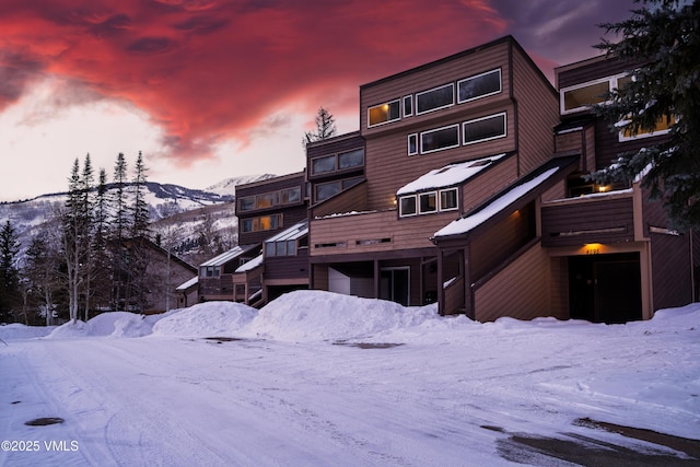 snow covered house featuring a mountain view