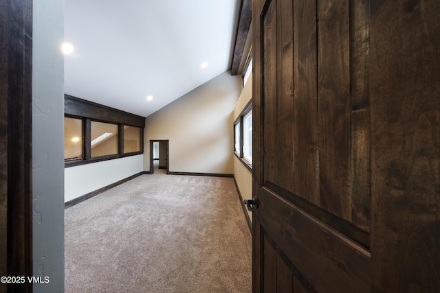 carpeted empty room with lofted ceiling with beams