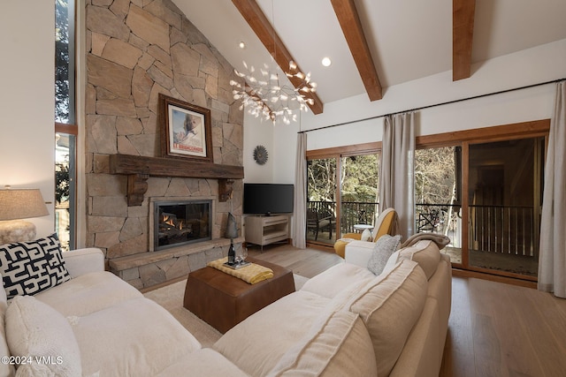 living room with beamed ceiling, a fireplace, light hardwood / wood-style flooring, and a notable chandelier