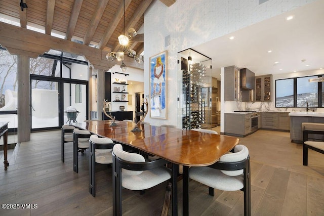 dining room with wood ceiling, light wood-style flooring, high vaulted ceiling, and beam ceiling