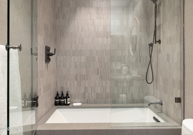 bathroom with toilet and tiled shower / bath