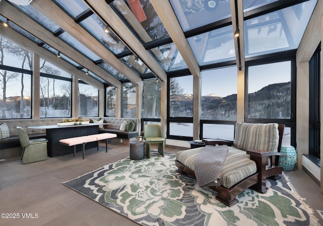 sunroom / solarium featuring a mountain view and track lighting