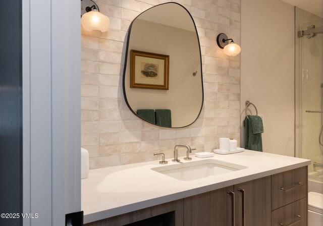 full bath featuring toilet, walk in shower, vanity, and decorative backsplash