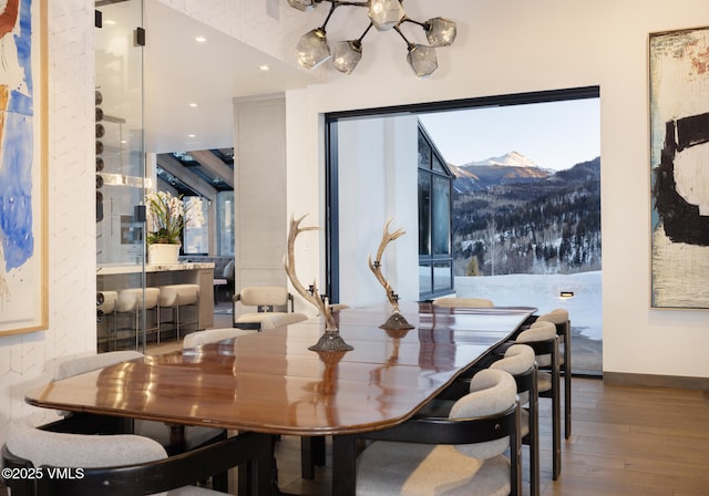 dining area featuring baseboards, wood finished floors, a mountain view, and recessed lighting