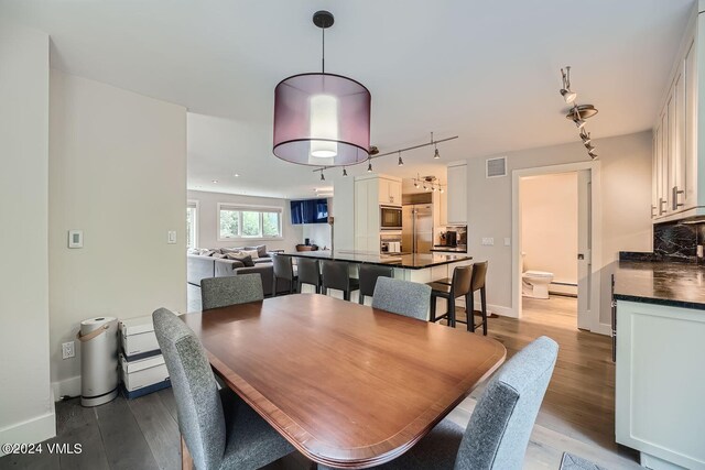 dining room featuring light hardwood / wood-style flooring, track lighting, and baseboard heating