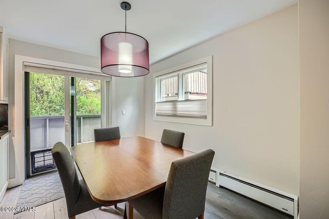 dining room with light hardwood / wood-style flooring and a baseboard heating unit