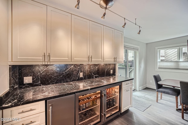 bar with dark wood-type flooring, dark stone countertops, backsplash, wine cooler, and white cabinets