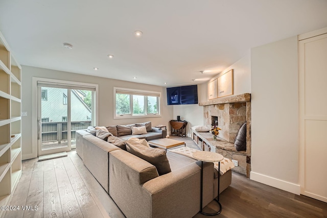 living room featuring a stone fireplace and hardwood / wood-style floors