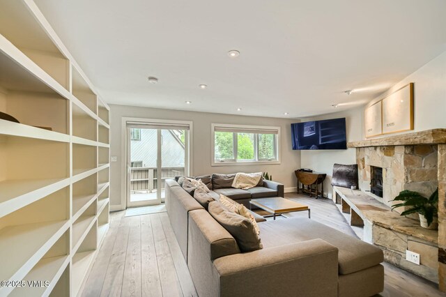 3930 Fall Line Dr Unit 12, Vail, CO 81657 - living room with light wood-type flooring, a stone fireplace, and recessed lighting