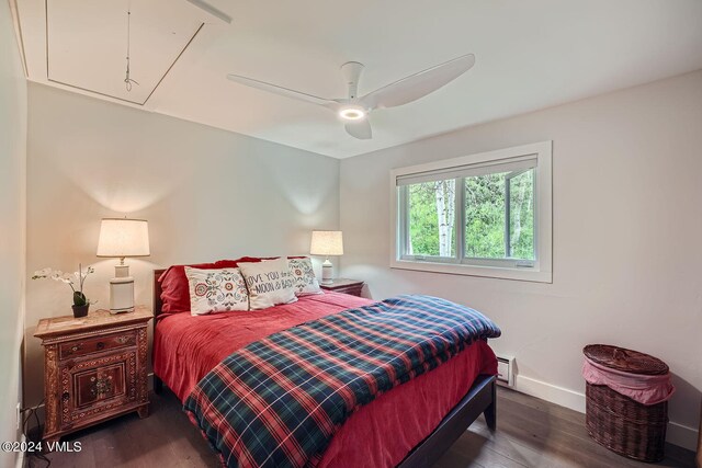 bedroom featuring dark wood-type flooring, ceiling fan, and baseboard heating