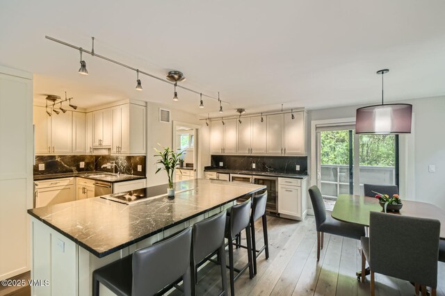 3930 Fall Line Dr Unit 12, Vail, CO 81657 - kitchen with beverage cooler, decorative backsplash, and a breakfast bar